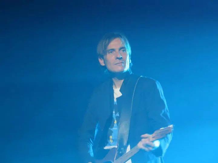 Nicolas Paillet, guitariste, sur scène dans une lumière bleue